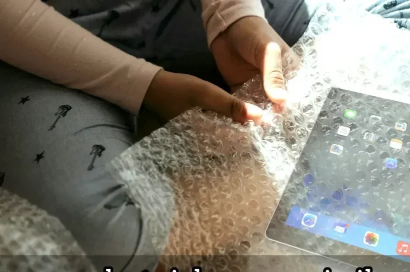 Frau wundert sich über iPad in Geschenk aus Luftpolsterfolie Frau wundert sich über iPad in Geschenk aus Luftpolsterfolie